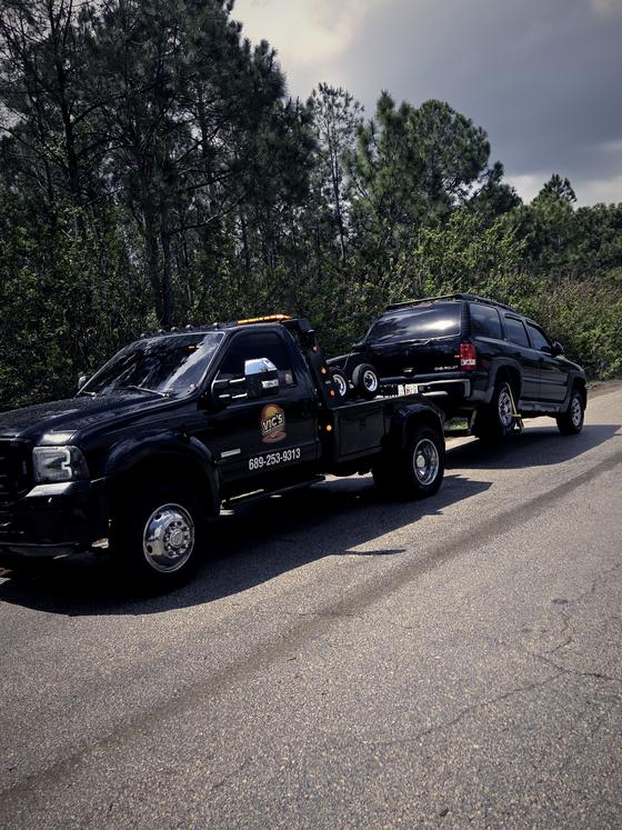 An SUV under tow on a wooded road outside Kissimmee.