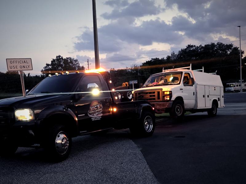 Vic's wrecker at dusk with amber strobes lit at a roadside call.