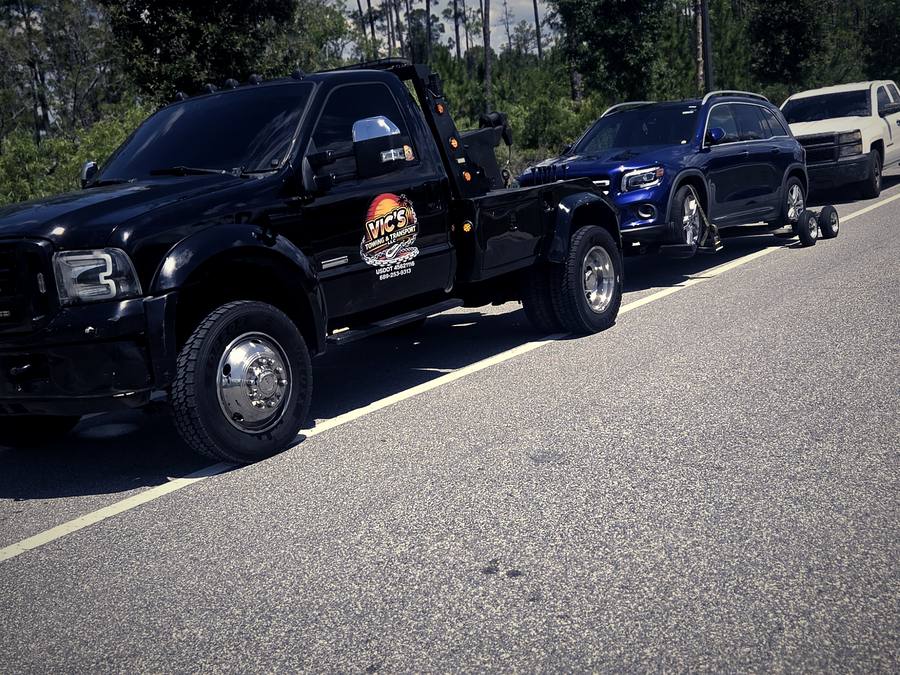 A blue SUV loaded on the wrecker for light duty towing.